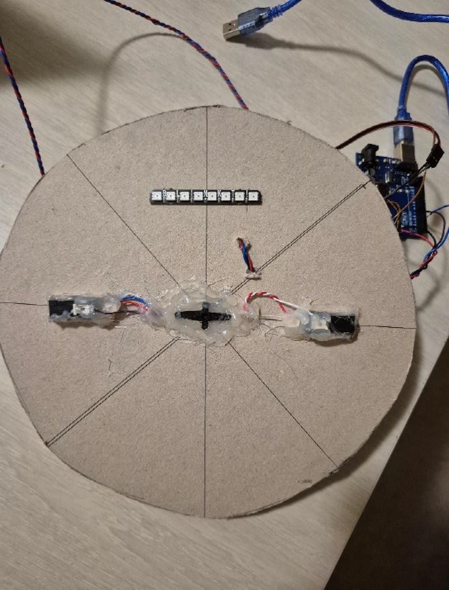 Top view of the circular racing wheel base with LED strip and paddle switches